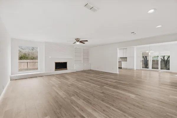 an empty room with wooden floor and fireplace
