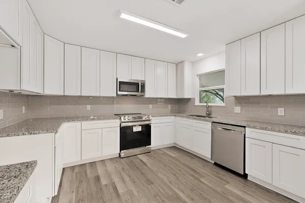 a view of empty room with wooden floor and fireplace