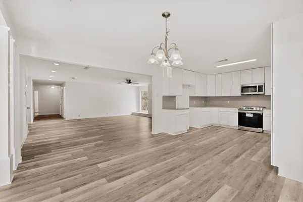 a view of a house with a yard and large tree