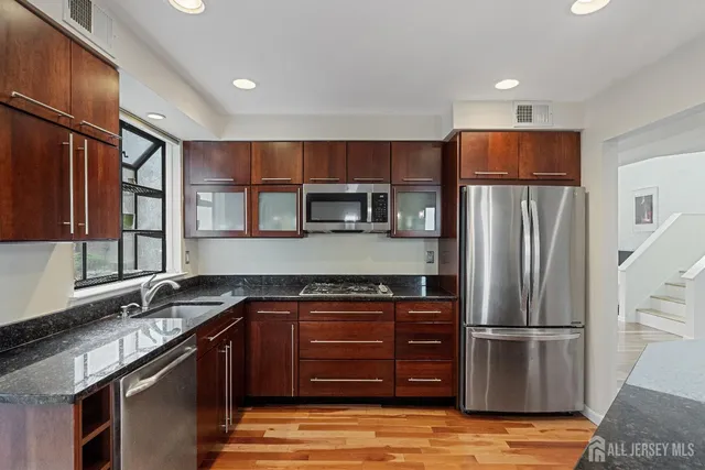 a kitchen with stainless steel appliances granite countertop a refrigerator and a sink