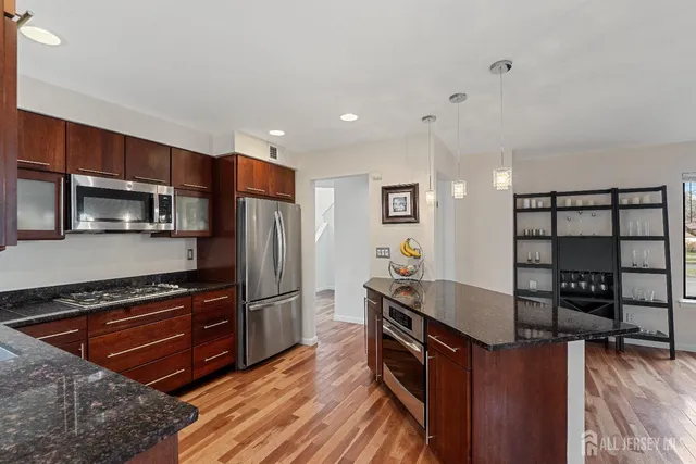 a kitchen with stainless steel appliances wooden cabinets a stove and a refrigerator