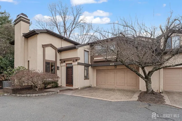 a view of a house with a garage and yard