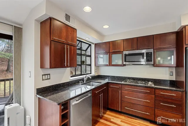 a kitchen with stainless steel appliances granite countertop a sink and a microwave
