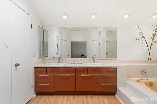 a bathroom with a granite countertop sink mirror and bathtub