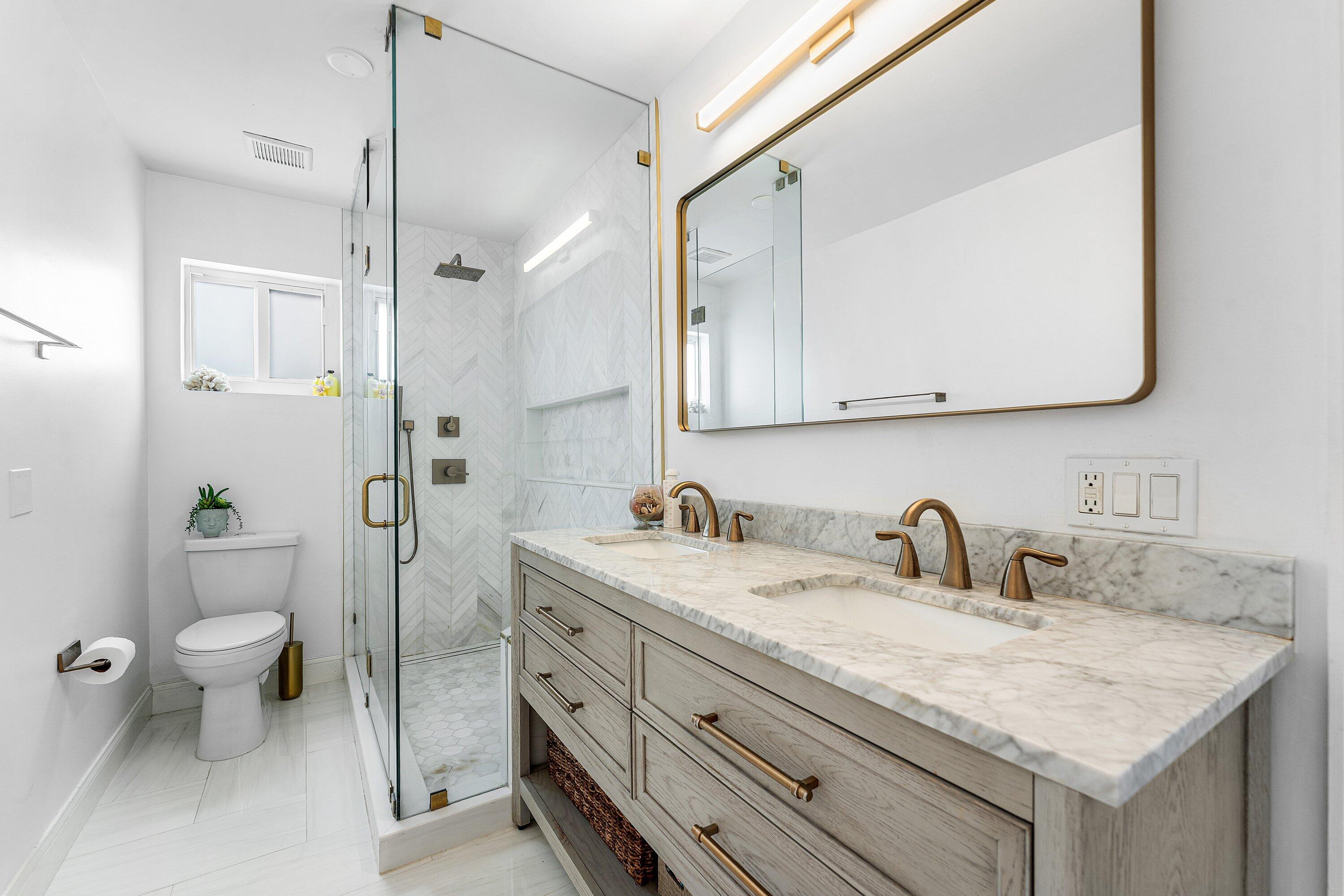 581 Northwest 13th Drive Boca Raton, FL 33486 - Photo 26 of 39 a bathroom with a granite countertop sink a toilet and a mirror