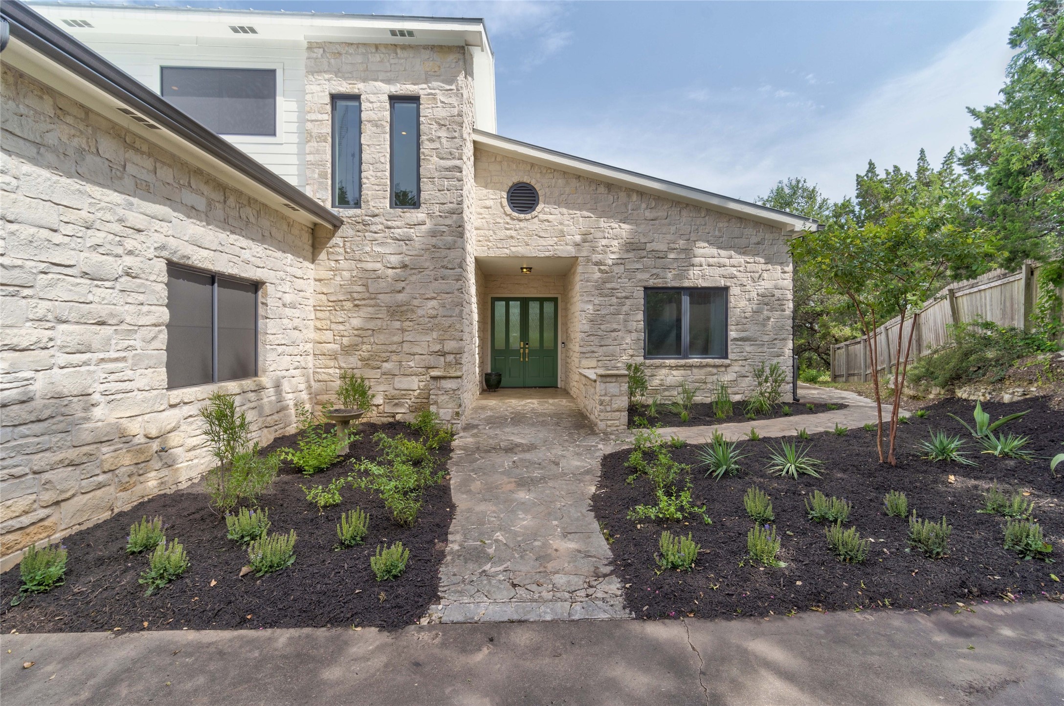 2102 Paisano Road Austin, TX 78746 - Photo 3 of 26 View of exterior entry with stone siding