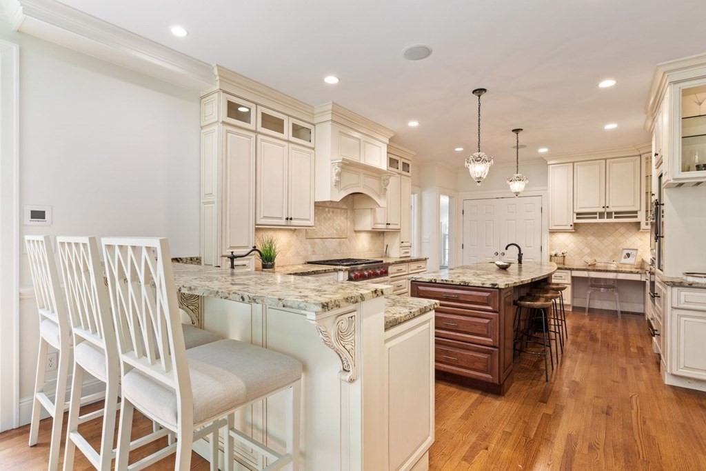 36 Audubon Road Wellesley, MA 02481 - Photo 20 of 40 a kitchen with stainless steel appliances granite countertop a stove top oven a refrigerator a sink and white cabinets with wooden floor