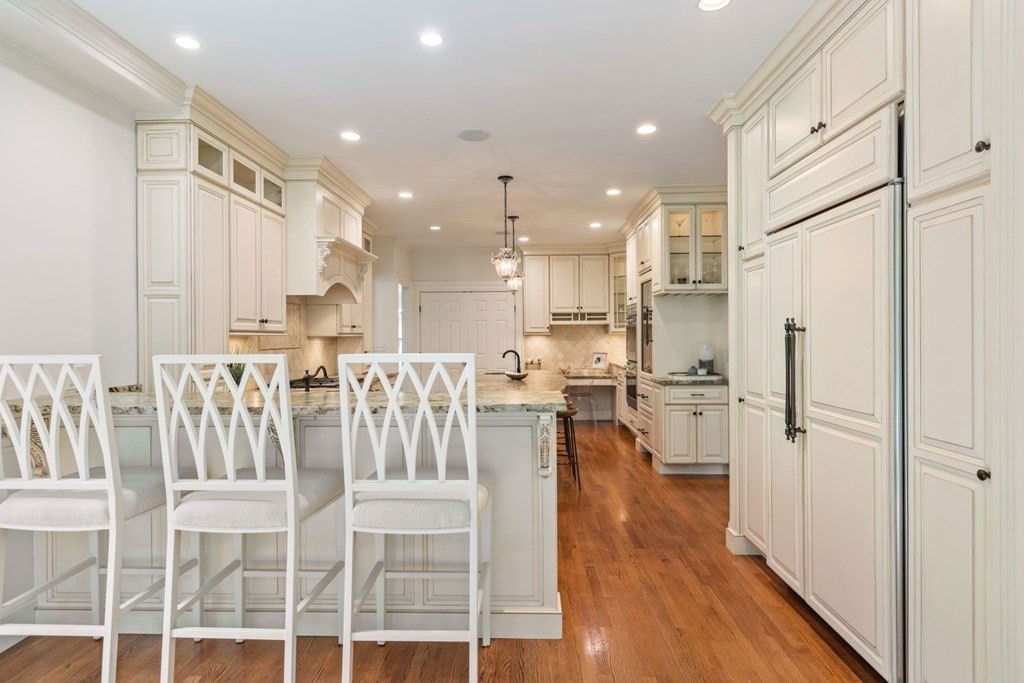 36 Audubon Road Wellesley, MA 02481 - Photo 21 of 40 a kitchen with stainless steel appliances kitchen island granite countertop a refrigerator a stove a sink and white cabinets with wooden floor