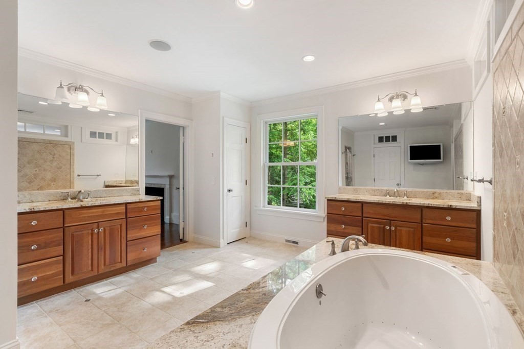 36 Audubon Road Wellesley, MA 02481 - Photo 32 of 40 a spacious bathroom with a granite countertop double vanity sink a bathtub and mirror