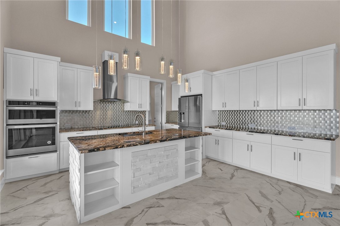 142 Wizard Way Spring Branch, TX 78070 - Photo 11 of 48 a kitchen with granite countertop a sink stove and cabinets