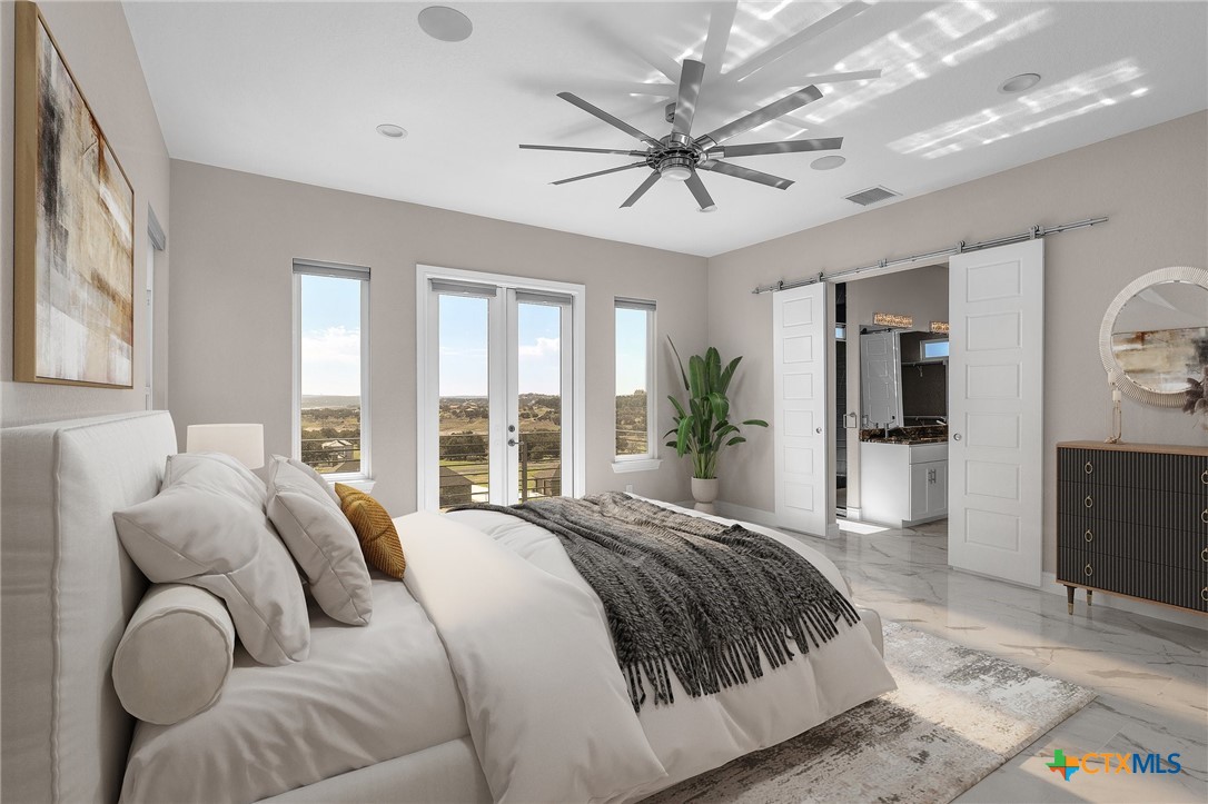 142 Wizard Way Spring Branch, TX 78070 - Photo 18 of 48 a spacious bedroom with a large bed and a chandelier