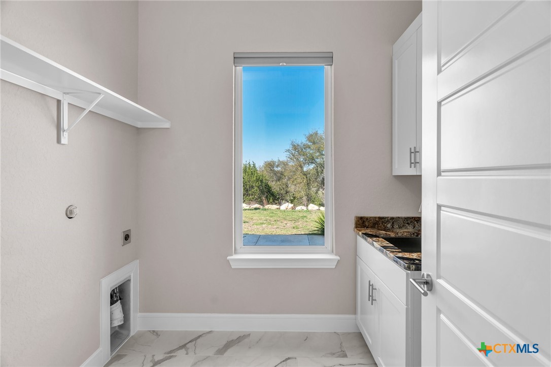 142 Wizard Way Spring Branch, TX 78070 - Photo 30 of 48 a kitchen with white cabinets and window