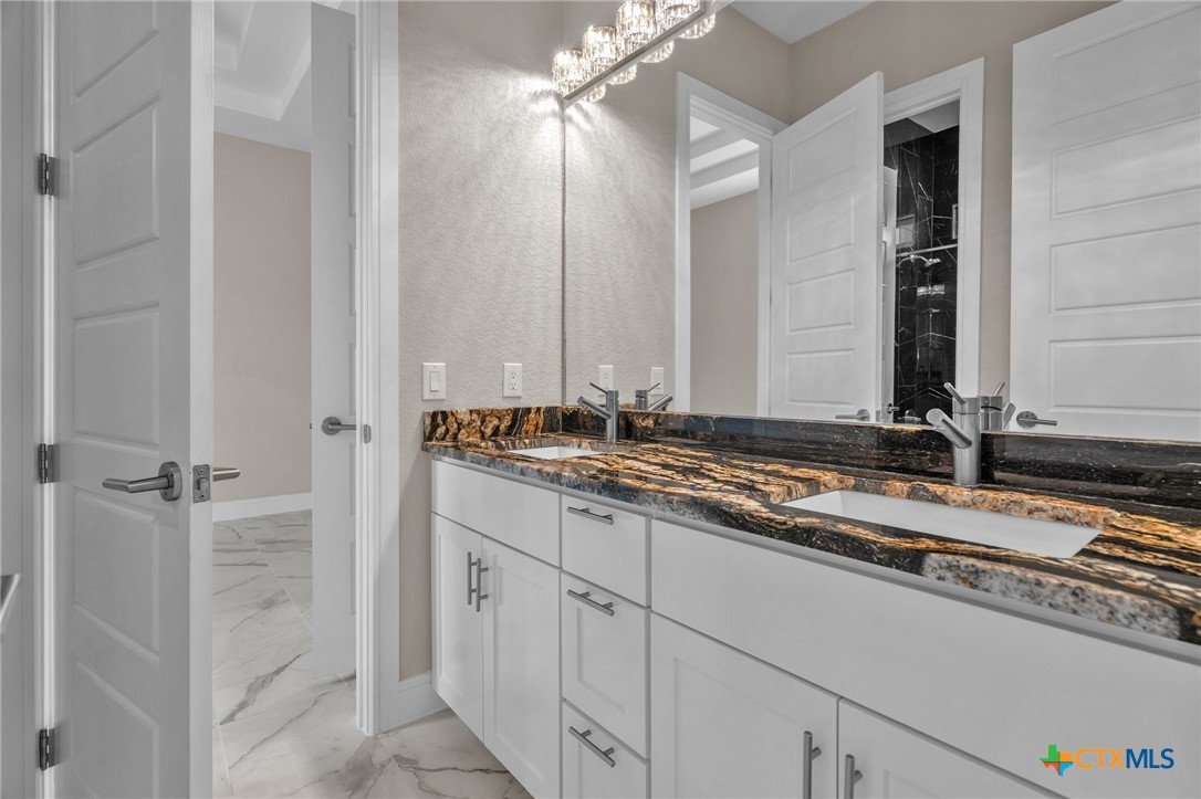142 Wizard Way Spring Branch, TX 78070 - Photo 32 of 48 a bathroom with a granite countertop sink and a mirror