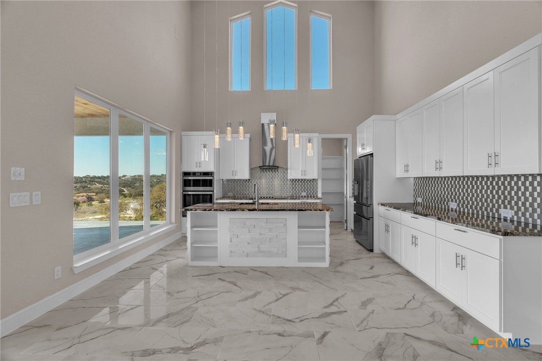 142 Wizard Way Spring Branch, TX 78070 - Photo 10 of 48 a large kitchen with a large window and stainless steel appliances