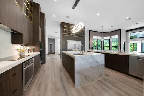 a kitchen with a table chairs refrigerator and couches