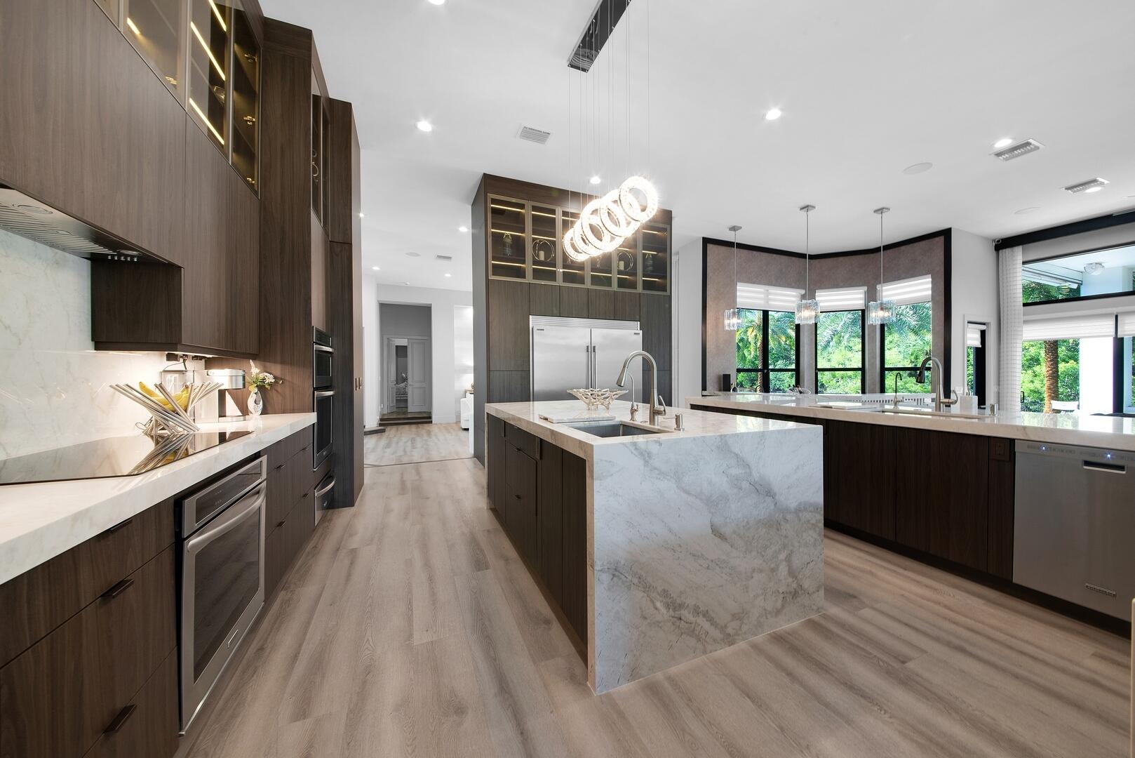 15271 Tall Oak Avenue Delray Beach, FL 33446 - Photo 29 of 60 a large kitchen with granite countertop a large counter top stainless steel appliances a sink and living room view