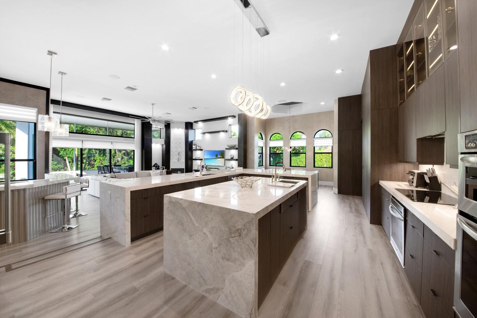 15271 Tall Oak Avenue Delray Beach, FL 33446 - Photo 31 of 60 a large kitchen with kitchen island a large counter top a sink a stove and a wooden floors