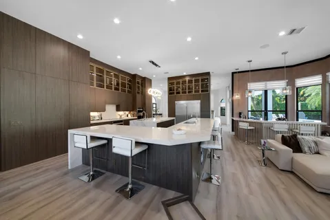 a kitchen with stainless steel appliances granite countertop a stove a kitchen island a dining table and chairs