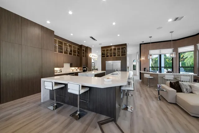 a kitchen with stainless steel appliances granite countertop a stove a kitchen island a dining table and chairs
