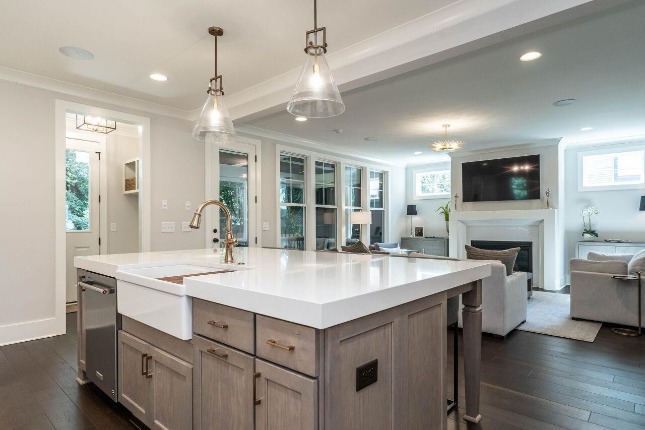 731 New Road Raleigh, NC 27608 - Photo 12 of 28 a view of living room kitchen island with stainless steel appliances granite countertop furniture and a fireplace