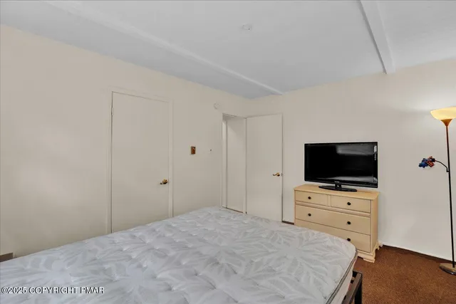 a bedroom with a bed and a flat screen tv