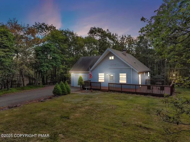 a front view of a house with a yard and trees