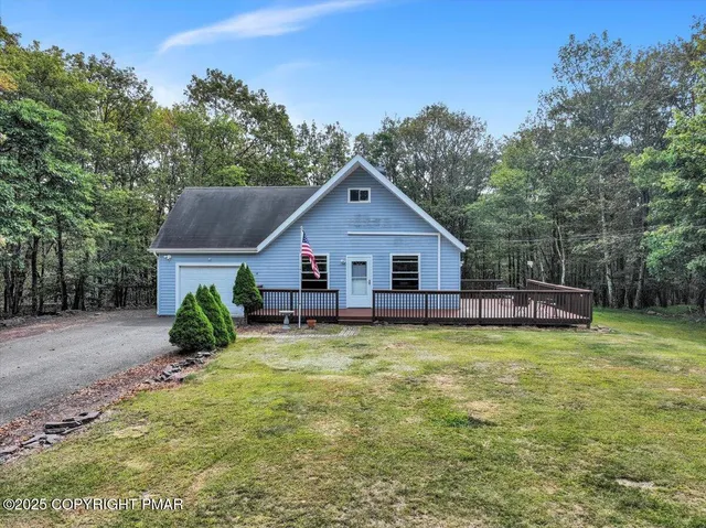 a view of a house with pool and a yard