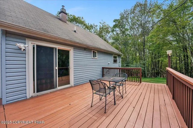 a view of backyard with a deck and wooden floor
