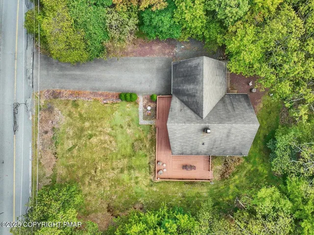 an aerial view of a house with garden space and a fountain