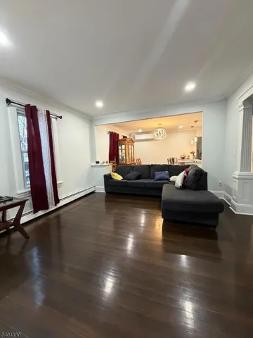 a dining room with wooden floor a chandelier a glass table and chairs