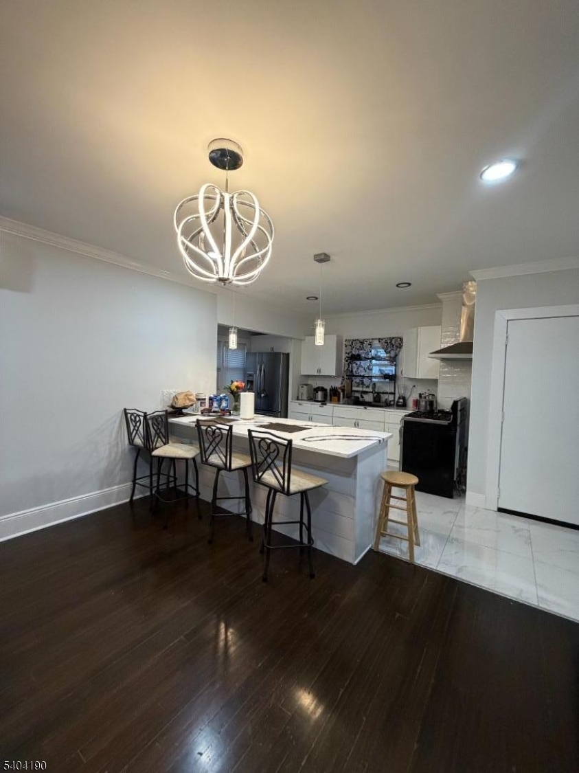 746 Murray Street, Unit 1 Elizabeth, NJ 07202 - Photo 10 of 28 a dining room with wooden floor a chandelier a glass table and chairs