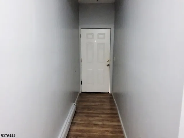 a view of a hallway with wooden floor and a staircase