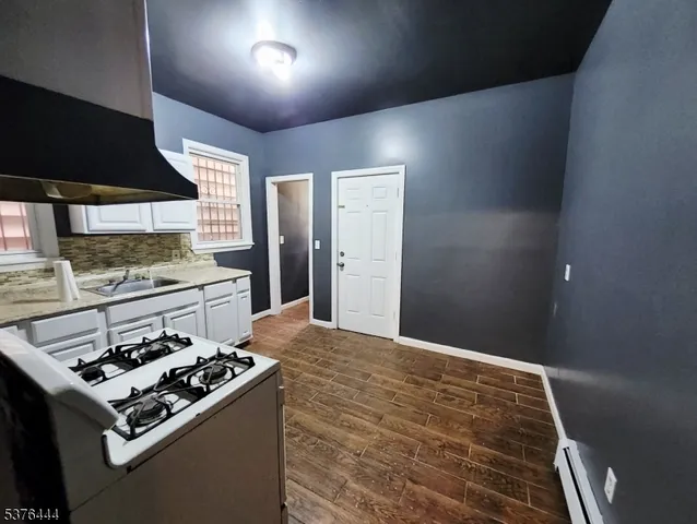 a kitchen with a stove and a wooden floor