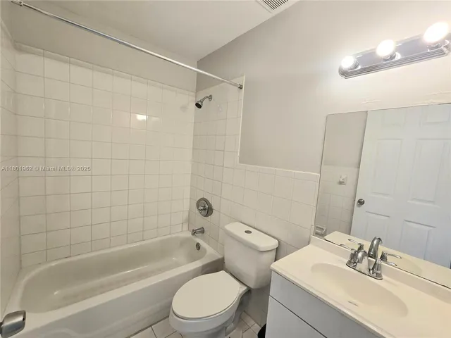 a bathroom with a bathtub shower sink mirror vanity and toilet