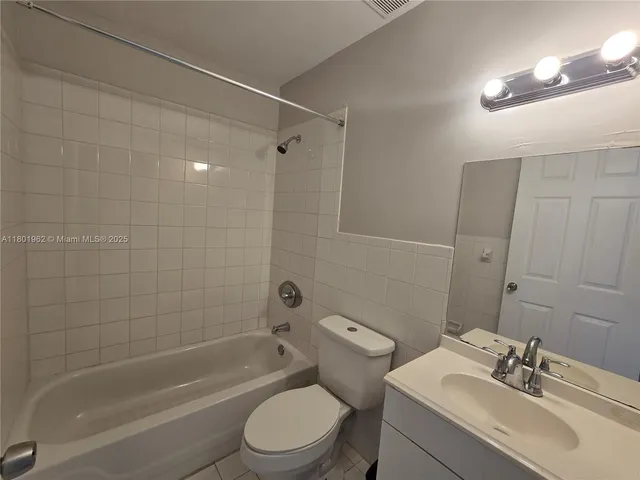 a bathroom with a bathtub shower sink vanity and toilet