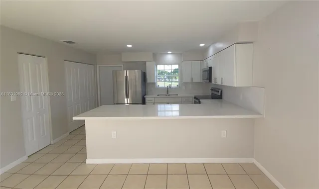 a view of a kitchen with white cabinets