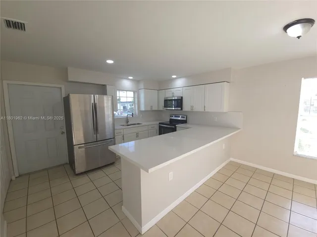 a view of a kitchen with electric appliances