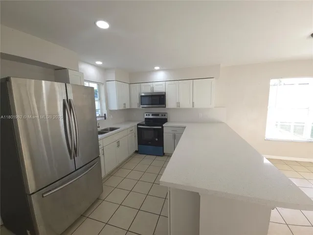 a kitchen with stainless steel appliances a refrigerator sink and microwave