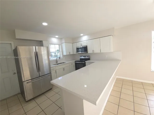 a kitchen with stainless steel appliances a refrigerator sink and microwave