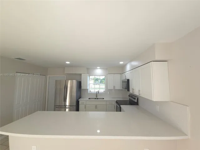 a view of kitchen with furniture and refrigerator