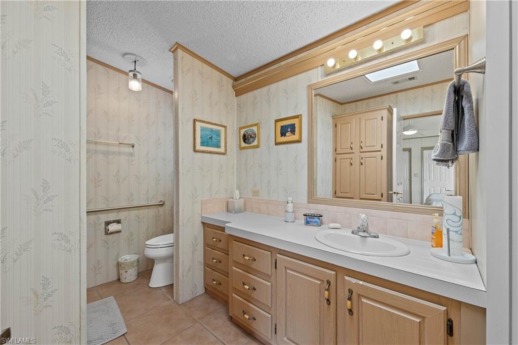 265 Riverwood Road Naples, FL 34114 - Photo 13 of 31 a bathroom with a toilet a double vanity sink and a mirror