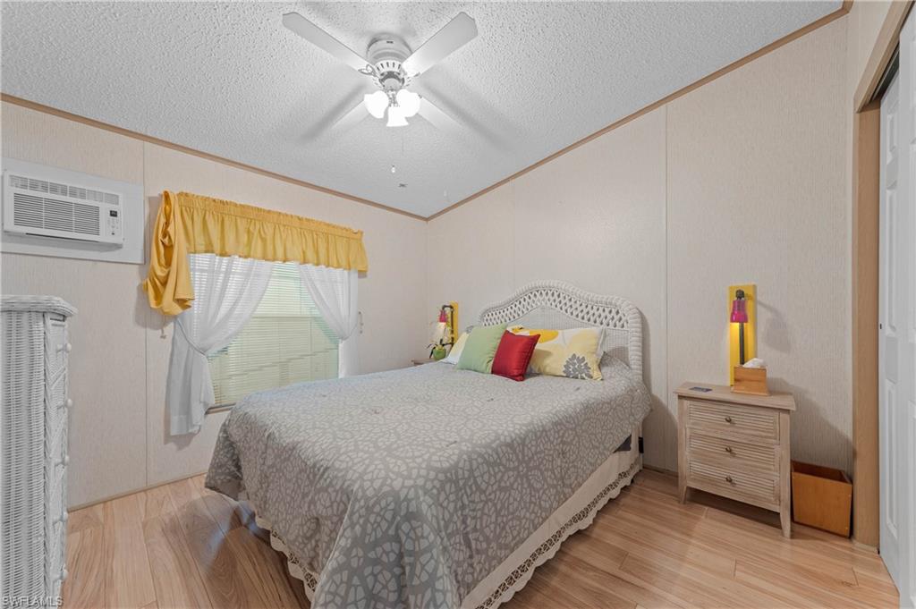 265 Riverwood Road Naples, FL 34114 - Photo 15 of 31 a bedroom with a bed and a chandelier
