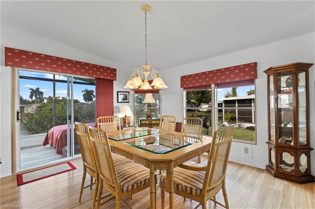 265 Riverwood Road Naples, FL 34114 - Photo 2 of 31 a view of a dining room with furniture wooden floor and chandelier