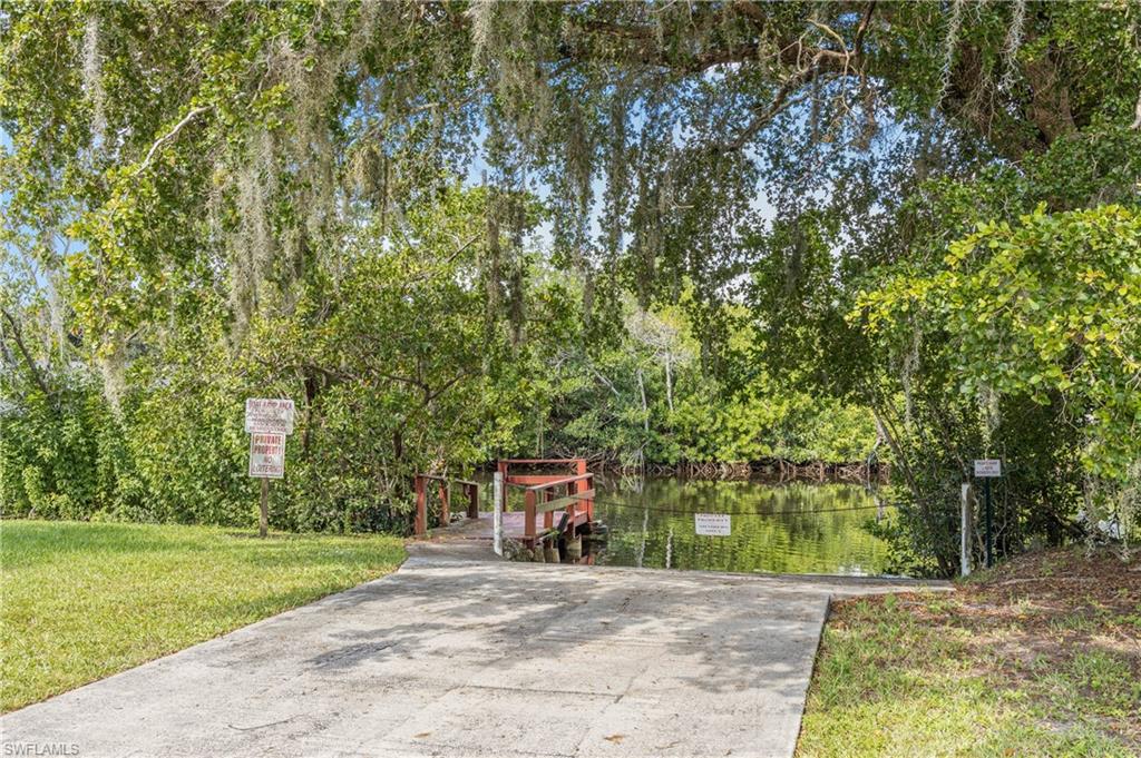 265 Riverwood Road Naples, FL 34114 - Photo 21 of 31 a front view of a house with a yard and shrubs