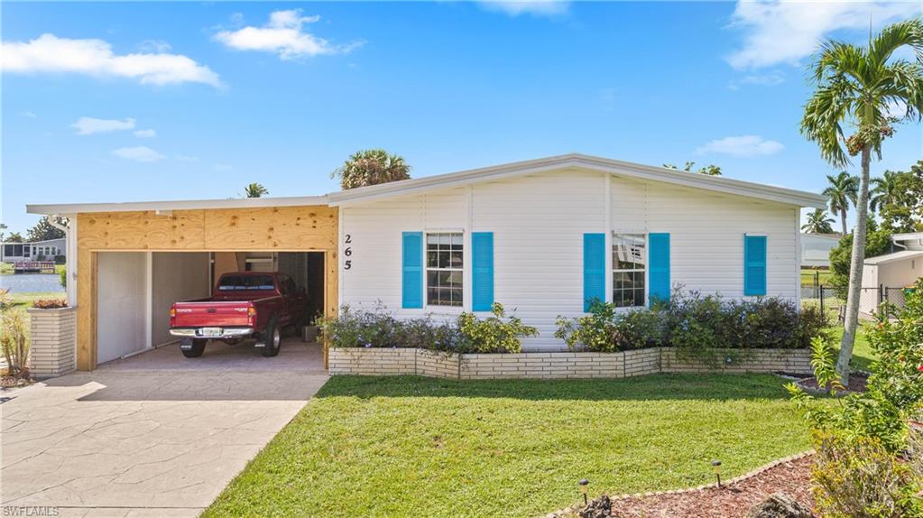 265 Riverwood Road Naples, FL 34114 - Photo 22 of 31 a front view of a house with garden