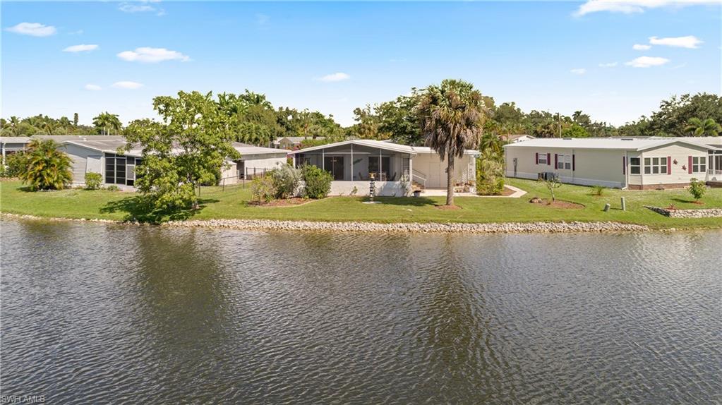 265 Riverwood Road Naples, FL 34114 - Photo 24 of 31 a front view of a house with a yard and lake view