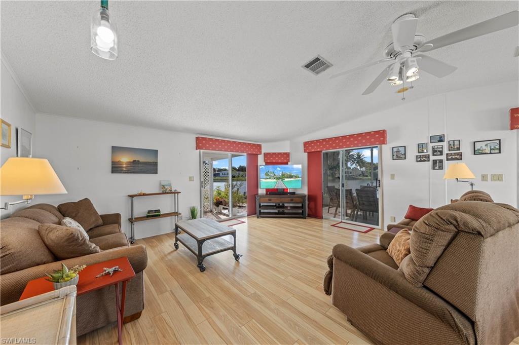 265 Riverwood Road Naples, FL 34114 - Photo 3 of 31 a living room with furniture a couch and a chandelier
