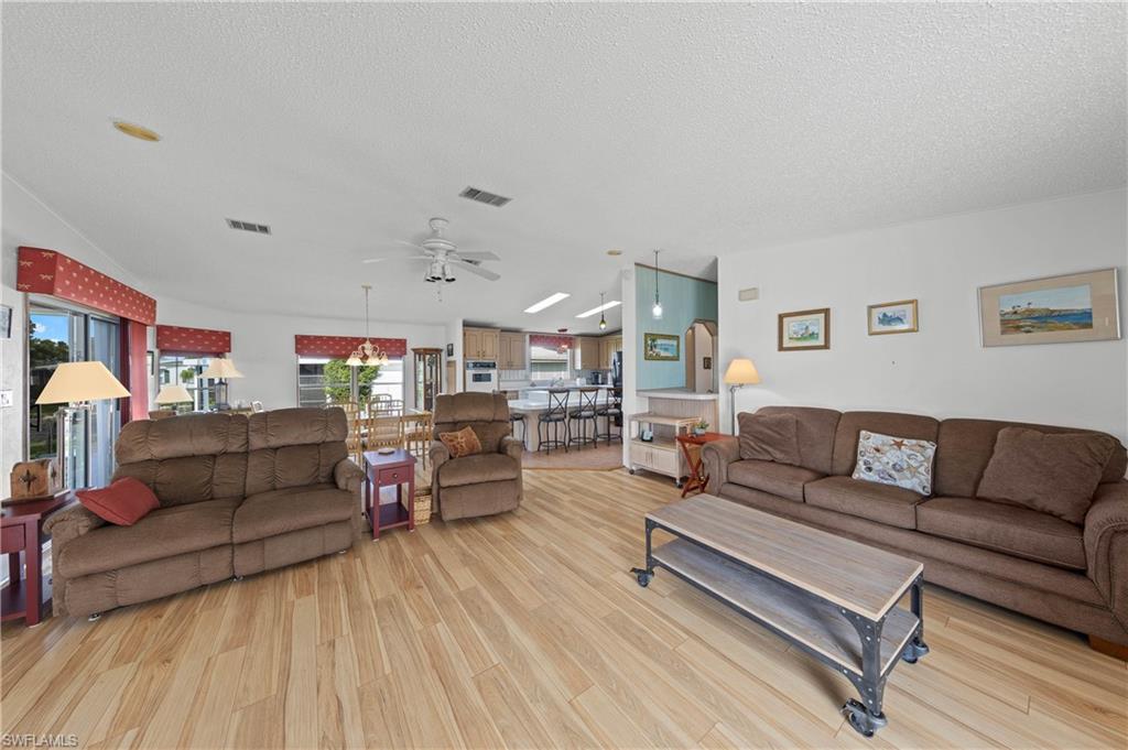 265 Riverwood Road Naples, FL 34114 - Photo 4 of 31 a living room with furniture and a wooden floor