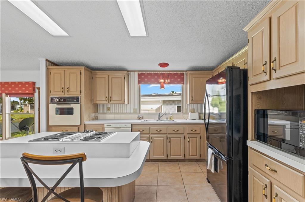 265 Riverwood Road Naples, FL 34114 - Photo 8 of 31 a kitchen with a sink stove and microwave