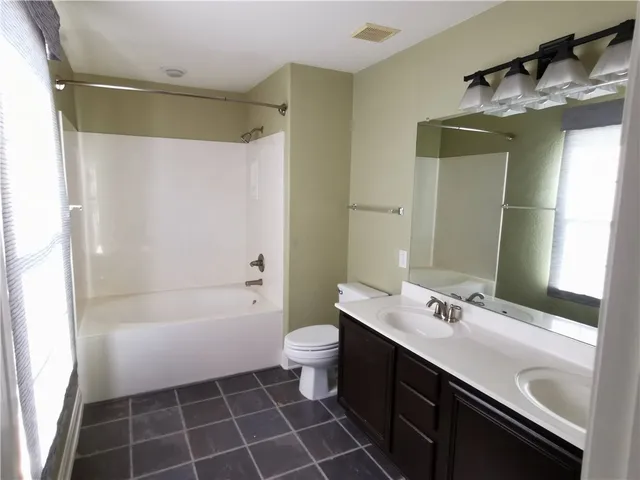 a bathroom with a double vanity sink mirror and shower
